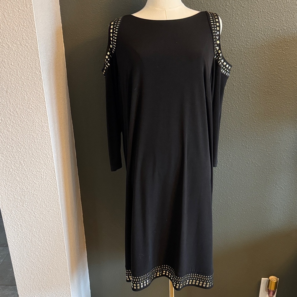 Cold shoulder black lined dress with gold accents on shoulder and bottom